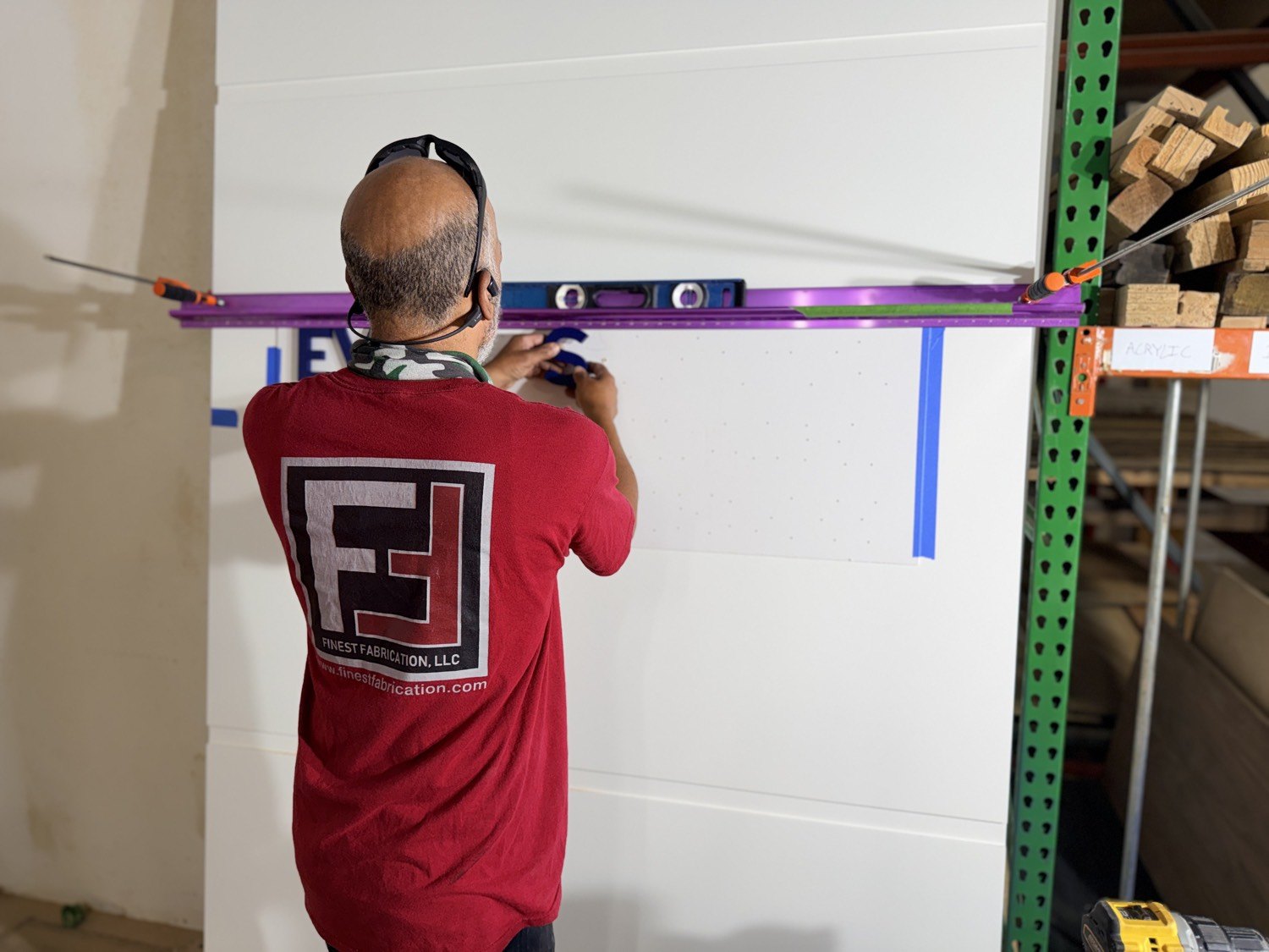 Crew laying out dimensional lettering on a panel