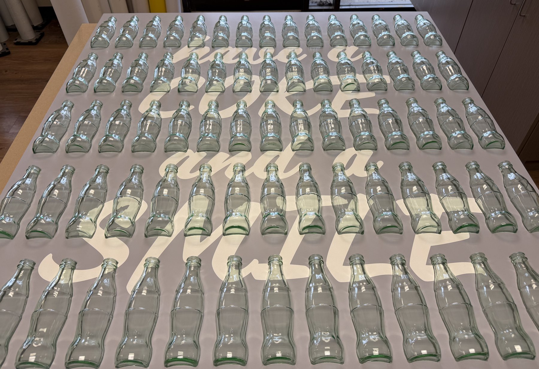 Coca-Cola bottle wall with Have a Coke and a Smile lettering