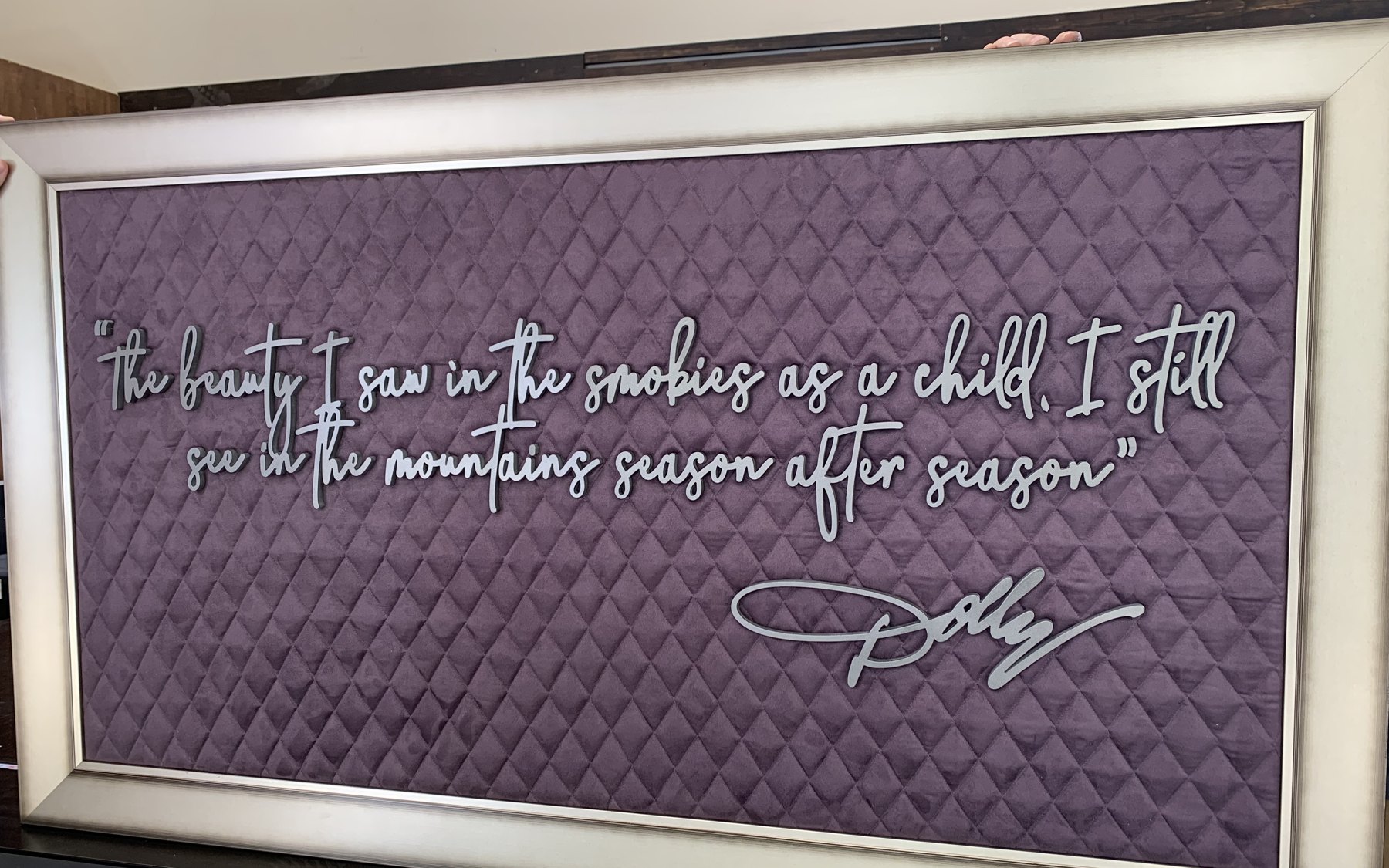 Framed Dolly Parton quote sign with dimensional lettering on a quilted field