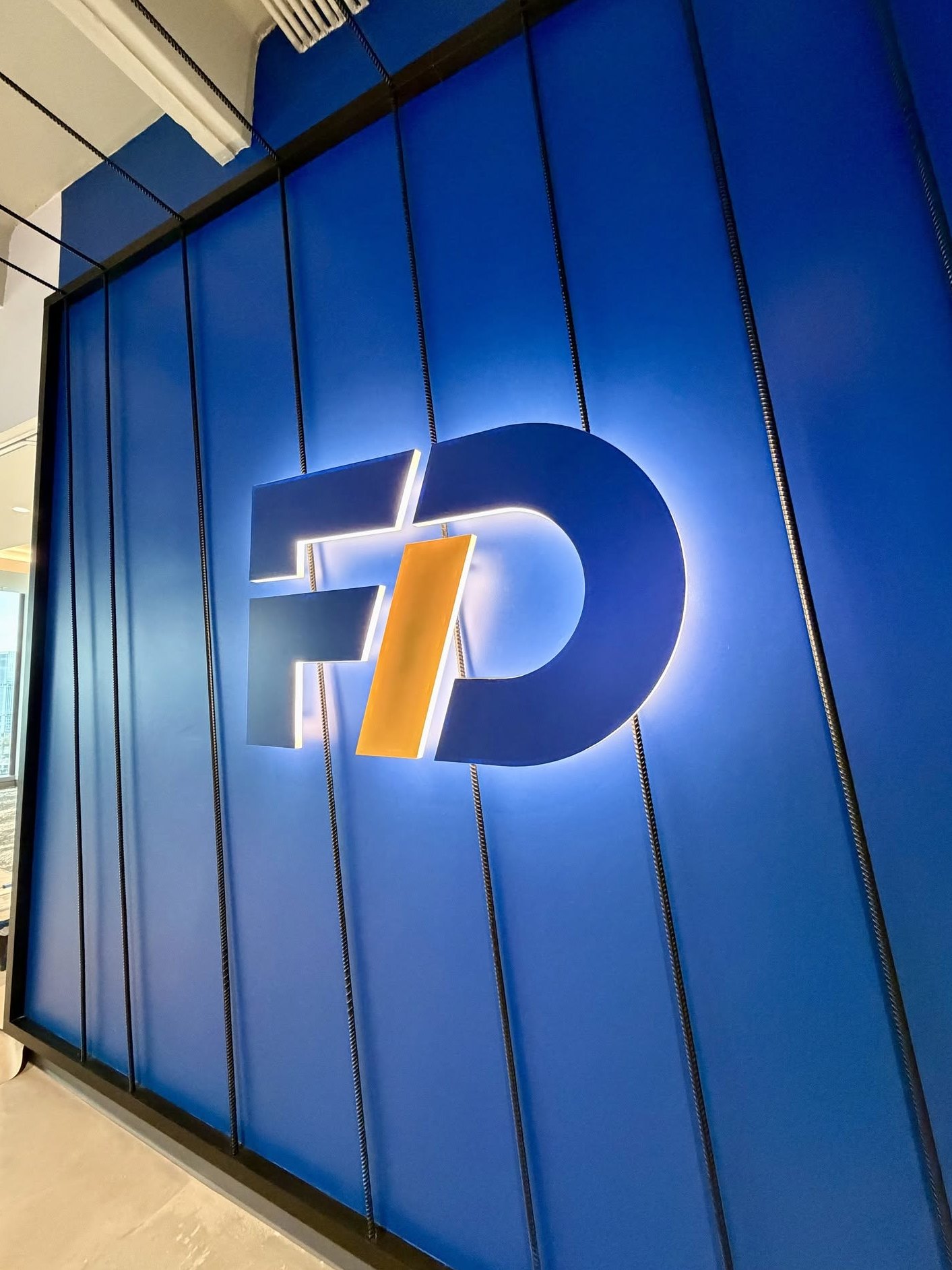 Halo lit FD logo on a painted slat wall