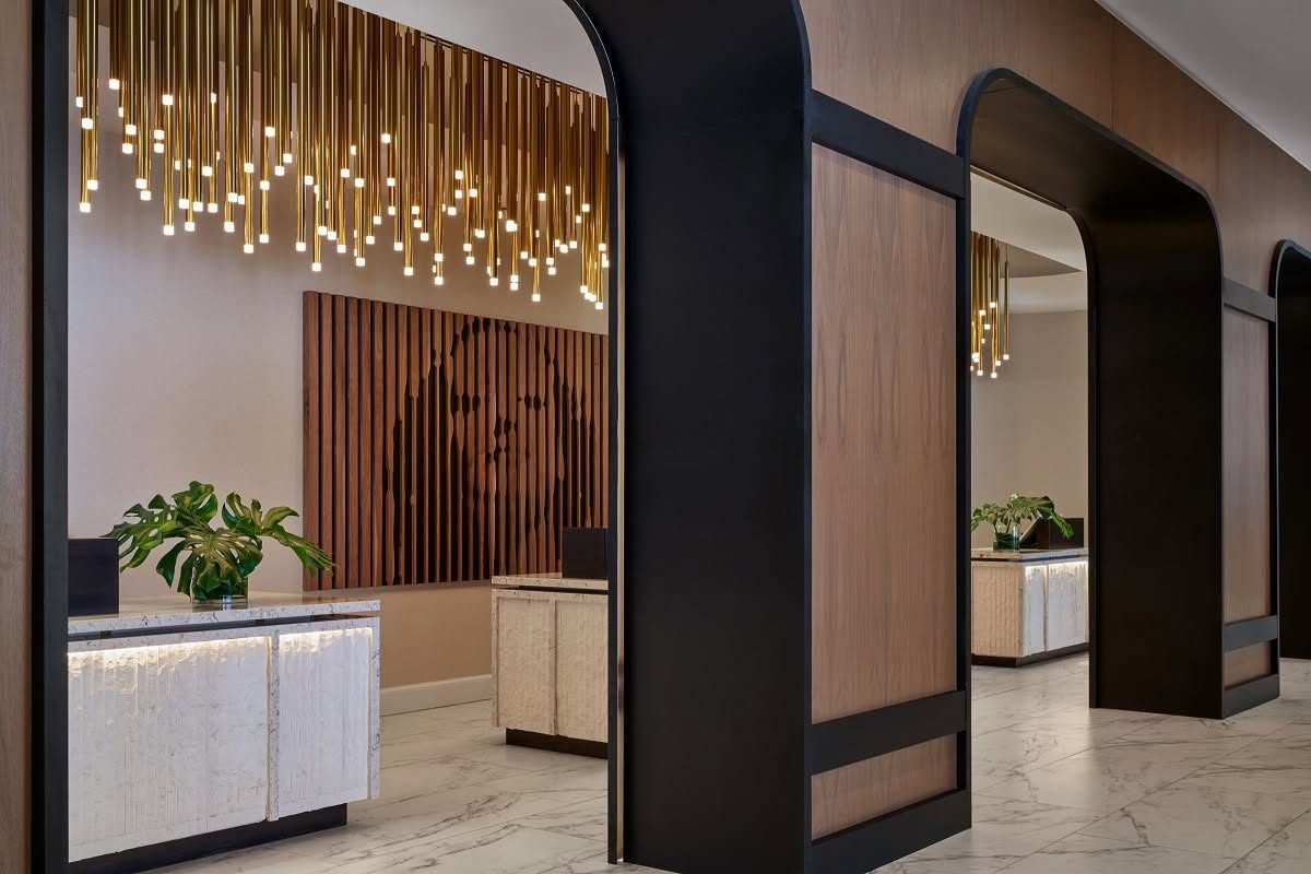 Hospitality lobby with sculptural wood wall and stone reception desks