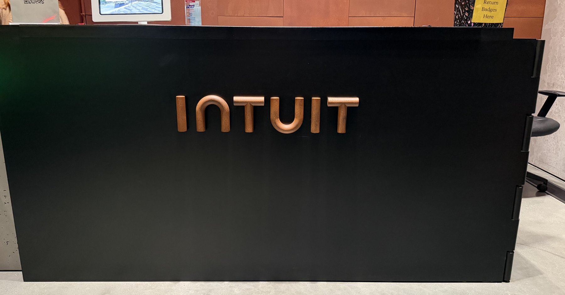 3D printed copper INTUIT letters on a black reception desk