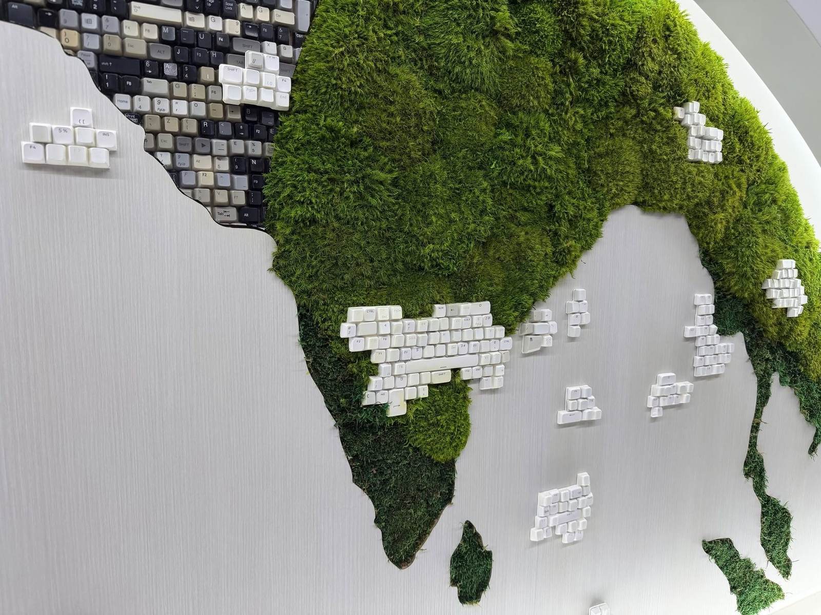 Close up of preserved moss and keyboard key islands on the world map
