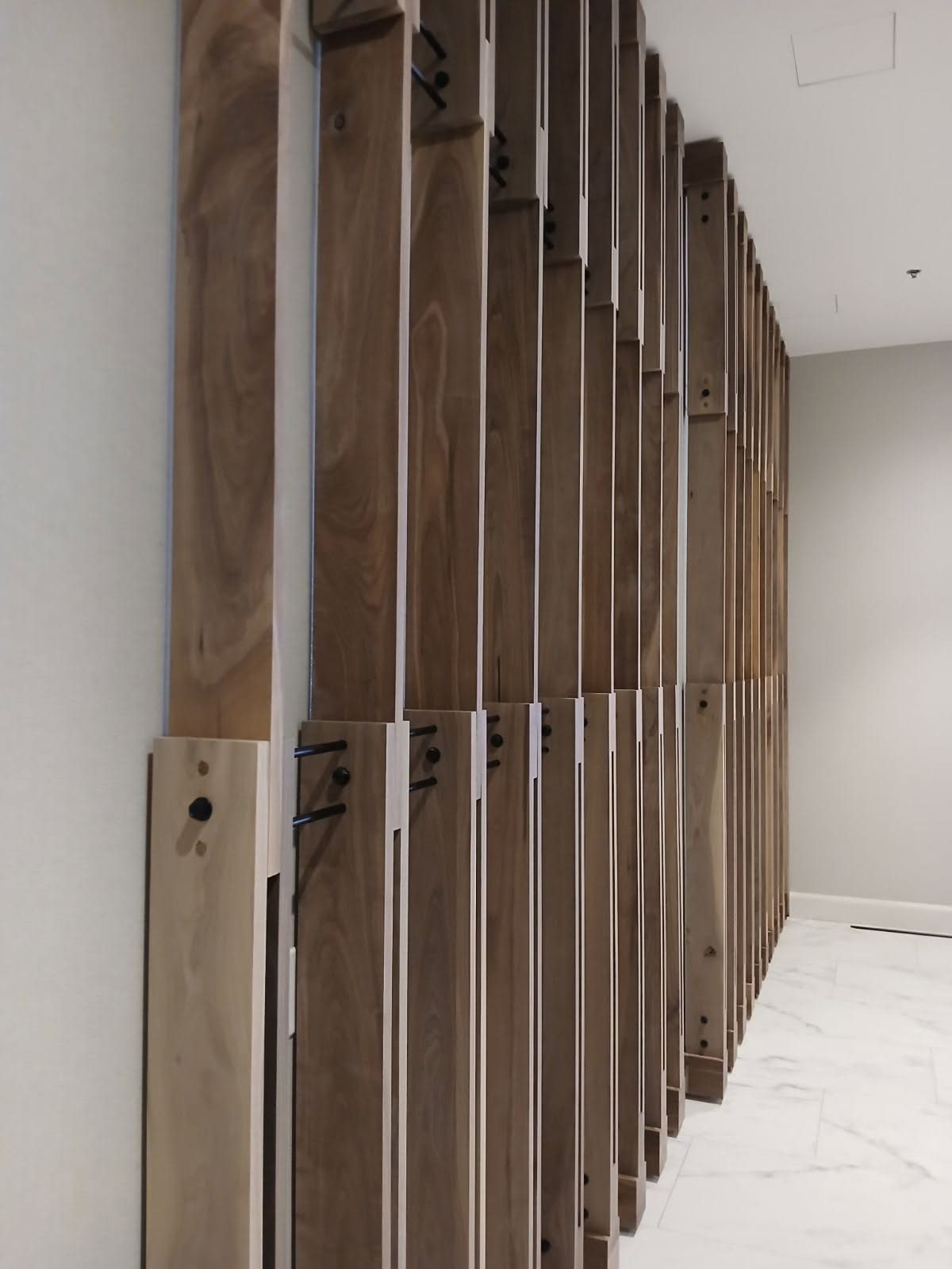 Walnut vertical slat feature wall with steel rod connections