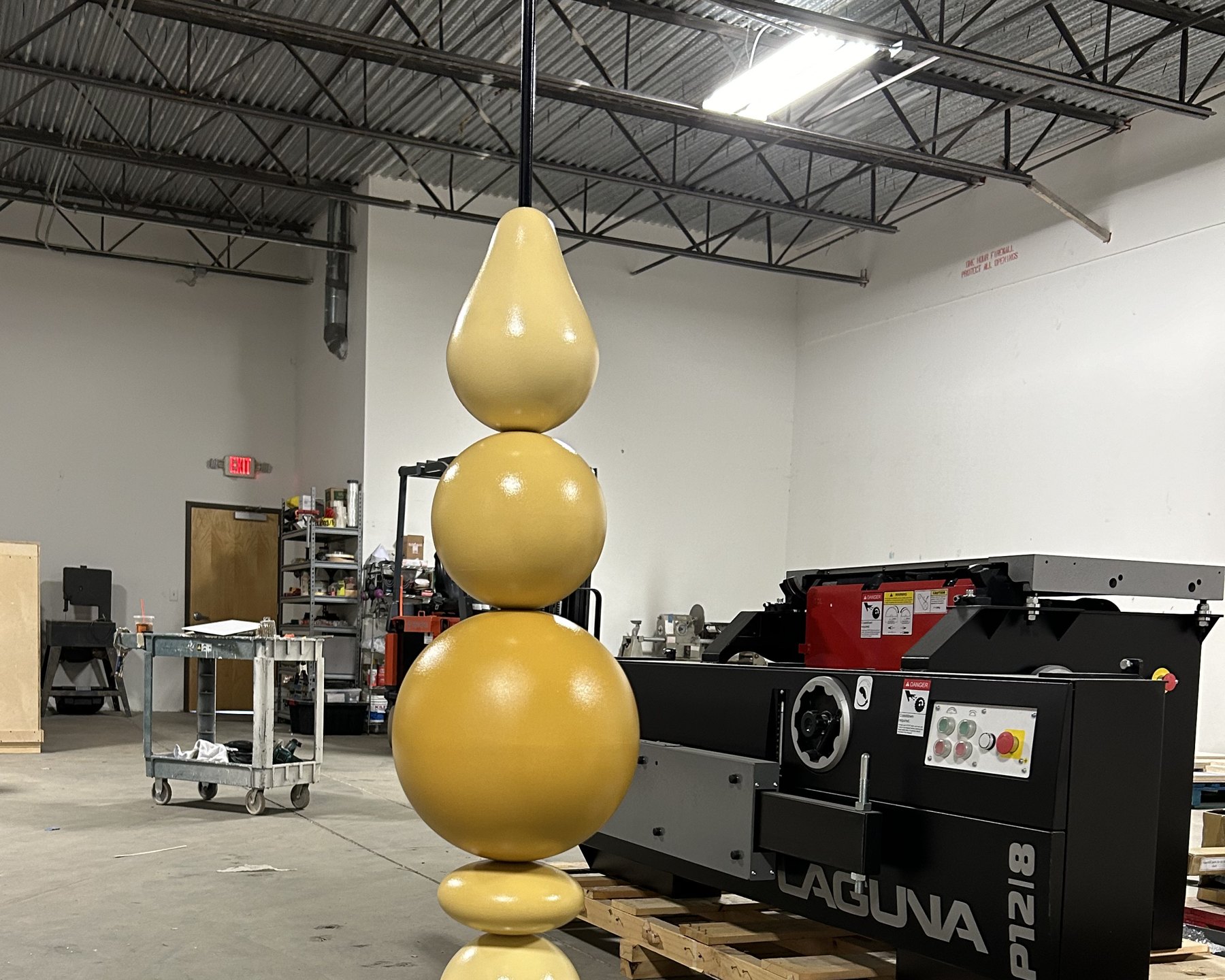 Stacked 3D printed sculptural form on a steel rod in the shop